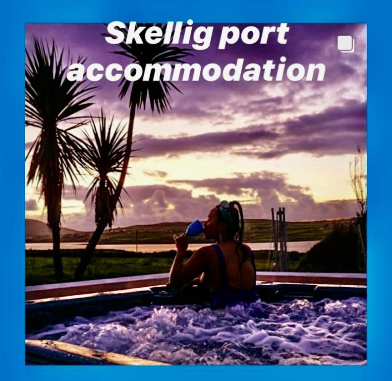 Skellig Port Accommodation - 1 Studio Bed Apartment في بورتماغي: امرأة جالسة في حوض استحمام ساخن وشرب