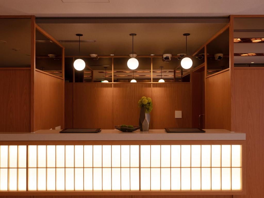 un vestíbulo con un mostrador con luces encendidas en MIMARU TOKYO ASAKUSA STATION, en Tokio