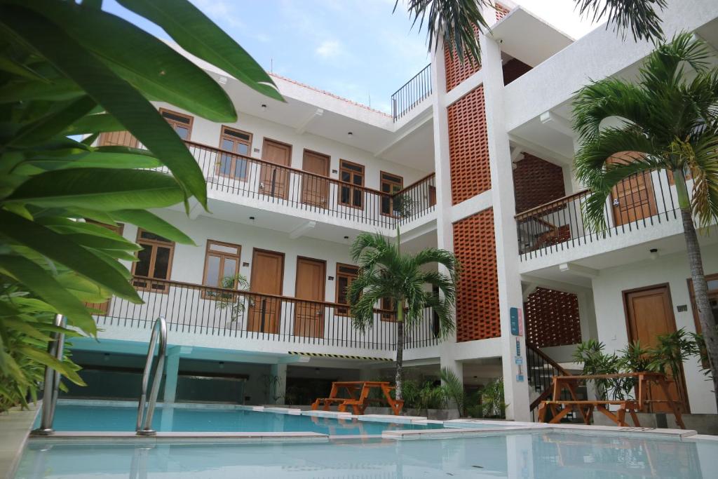 a hotel with a swimming pool in front of a building at Liberta Malioboro in Yogyakarta