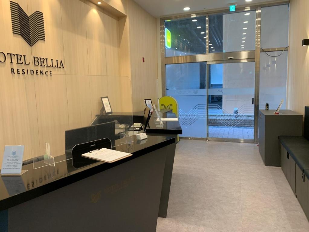 an office with a reception desk and a sign on the wall at Hotel Bellia in Busan