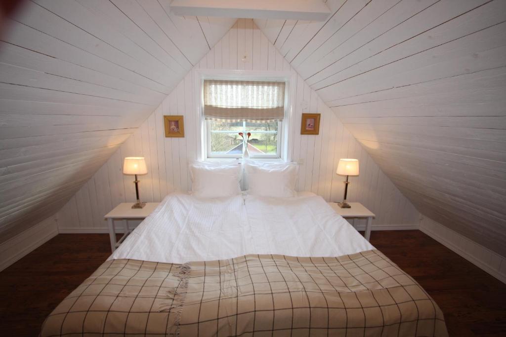 a bedroom with a large white bed in a attic at Hallagärde Gård in Frillesås