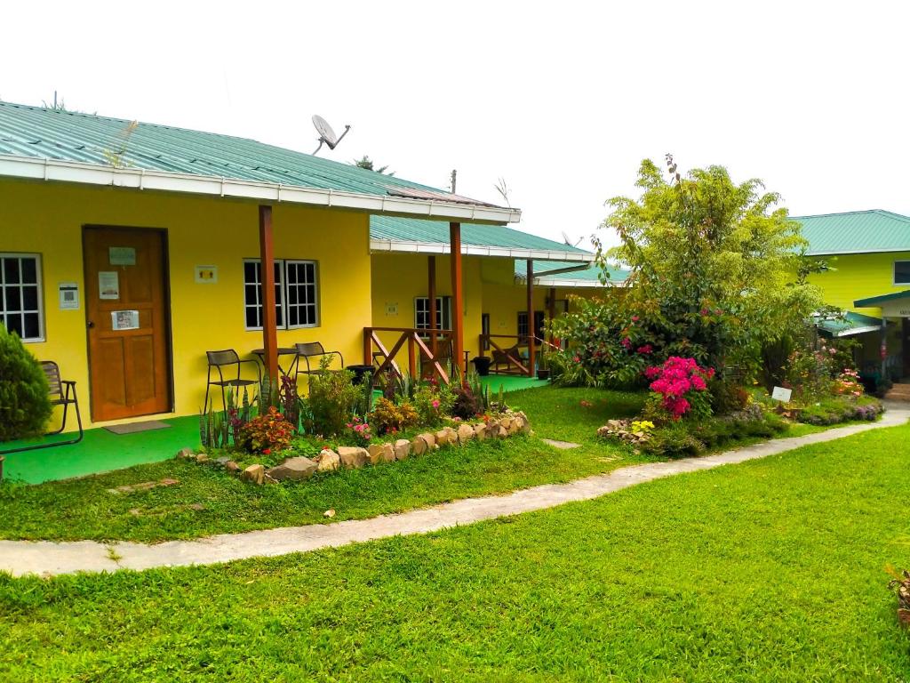 a yellow house with a garden in front of it at Soboroong Farmer's Cottage in Kundasang