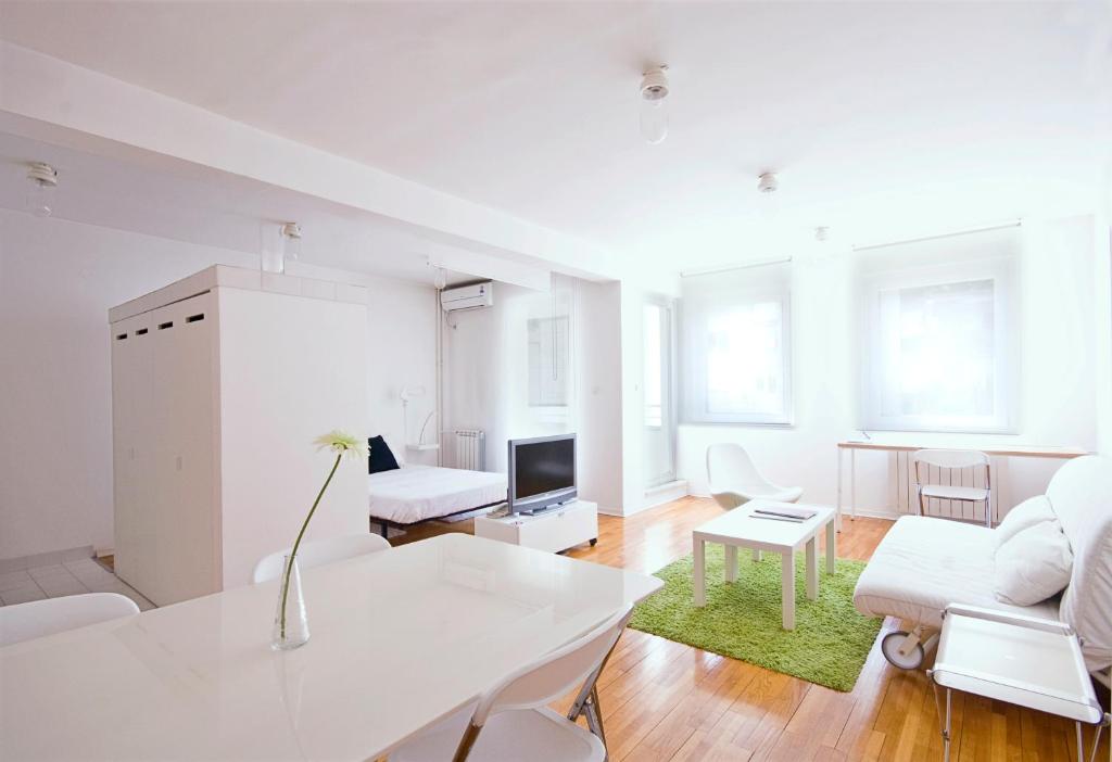 een witte woonkamer met een witte tafel en een bank bij Miu Arena Apartment in Belgrado
