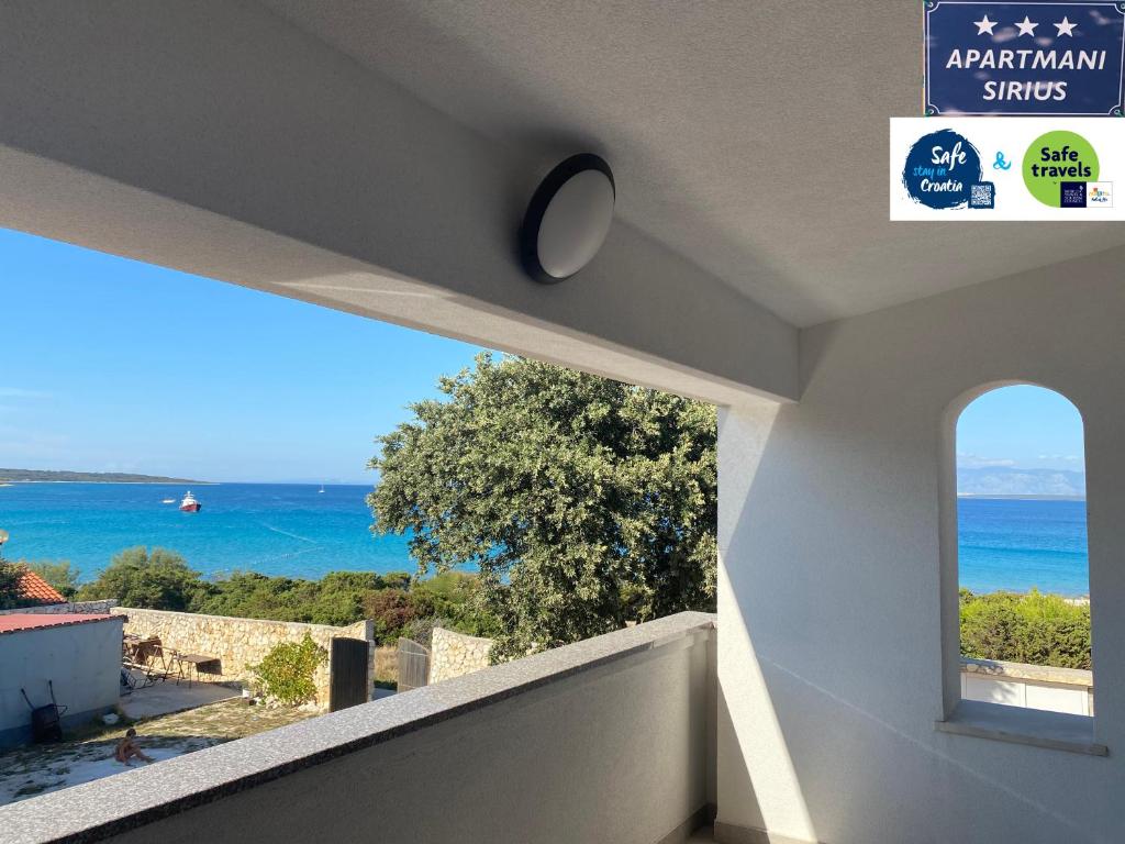 a view of the ocean from the balcony of a house at Apartmani Sirius in Silba