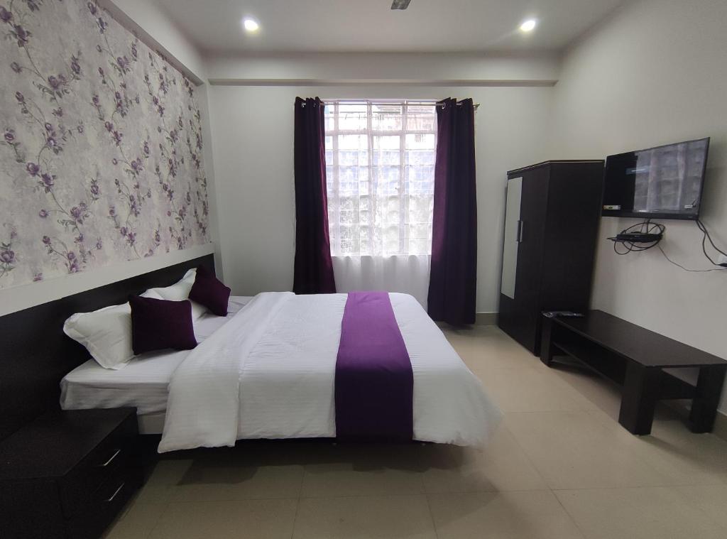 um quarto com uma cama grande e uma janela em Cassiopeia Guest House em Shillong