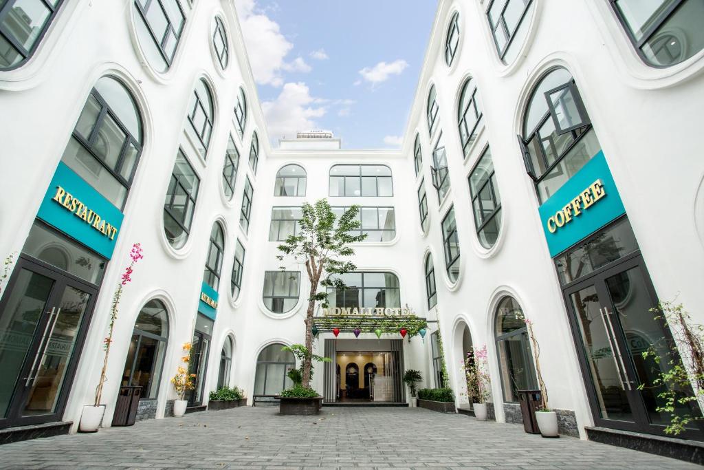 a large white building with large windows at MOMALI Hotel Ninh Binh in Ninh Binh