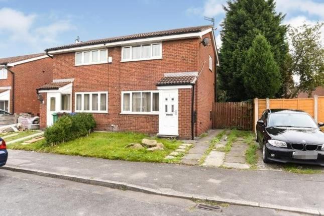 a brick house with a car parked in front of it at GARDNER HOLIDAYS HOUSE in Manchester