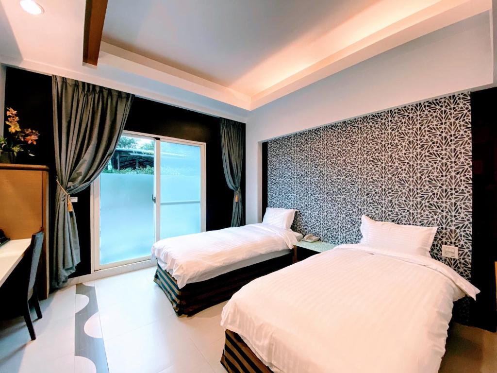 a bedroom with two beds and a window at Spring Fountain Hotel in Jiaoxi