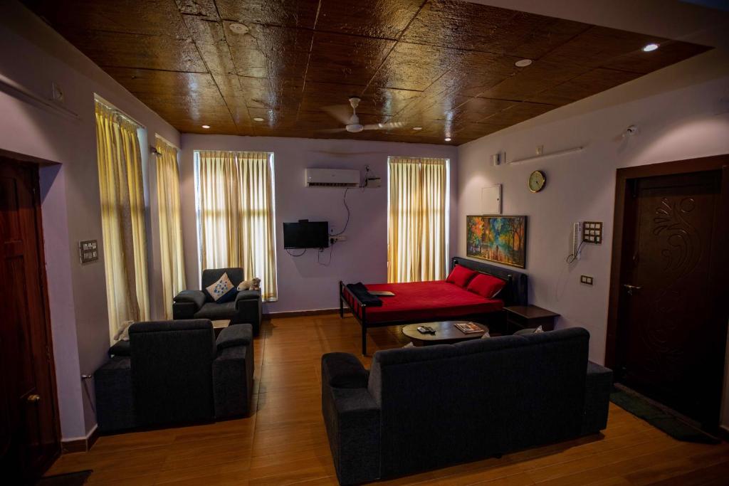 uma sala de estar com um sofá vermelho e cadeiras em Waves Beach House em Pondicherry