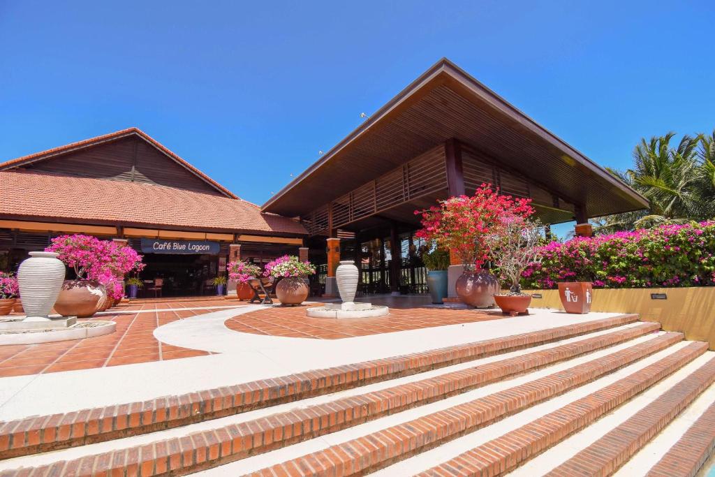 a building with stairs and flowers in front of it at Pandanus Resort in Mui Ne