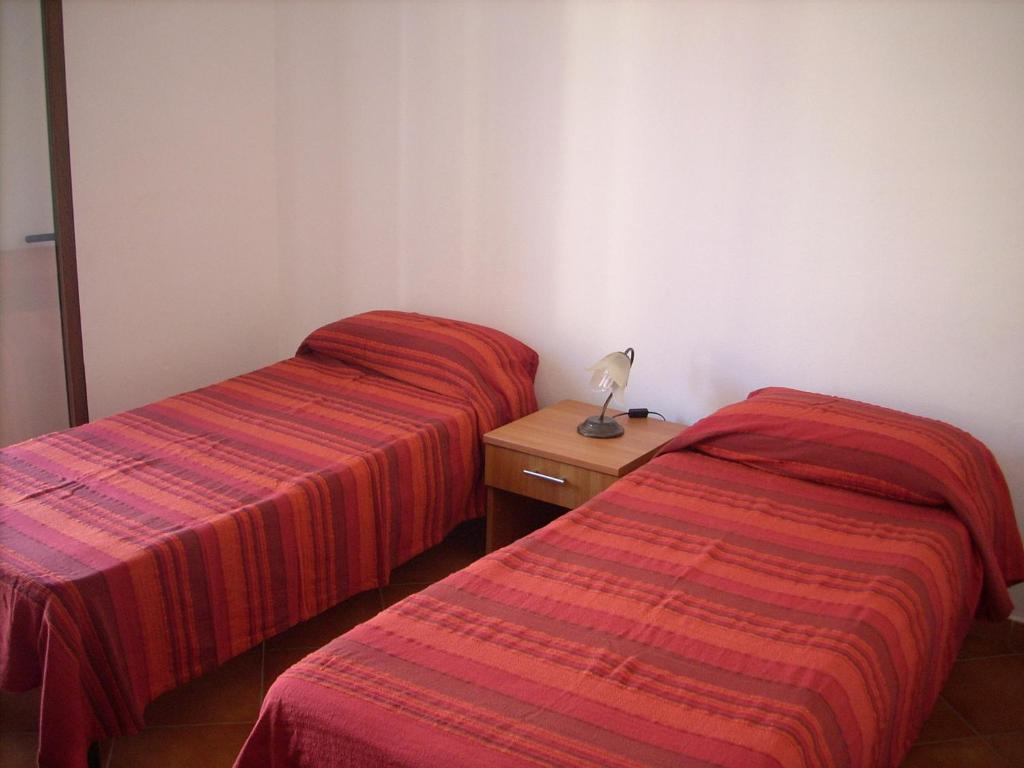 two beds sitting next to each other in a room at Yellon House in Santa Maria Navarrese