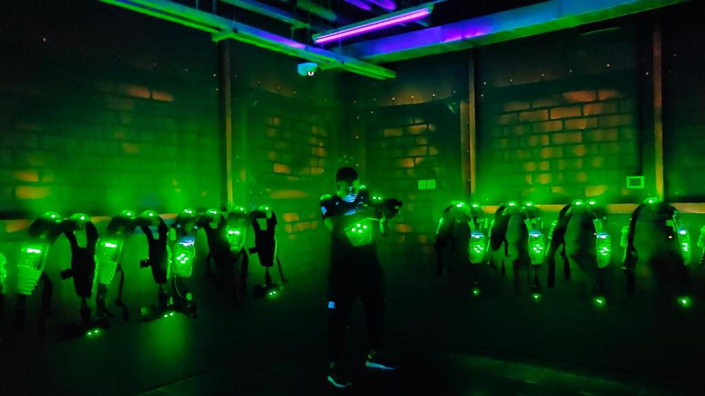 a man standing in a room with green lights at Royal M Hotel Fujairah by Gewan in Fujairah