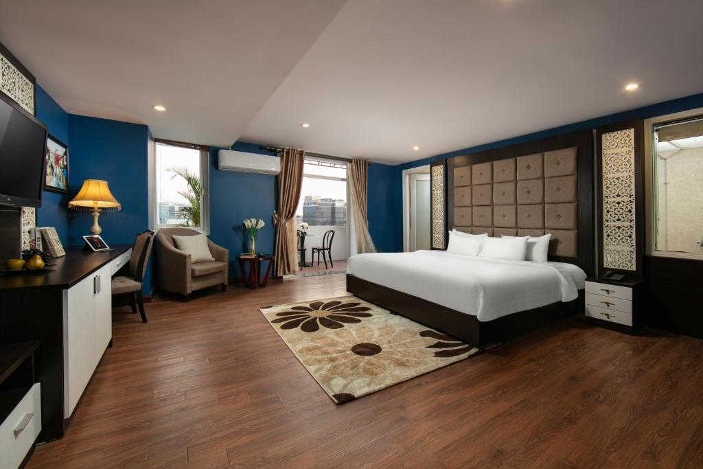 ハノイにあるHanoi 20 Hotel & Apartmentのベッドとリビングルームが備わるホテルルームです。