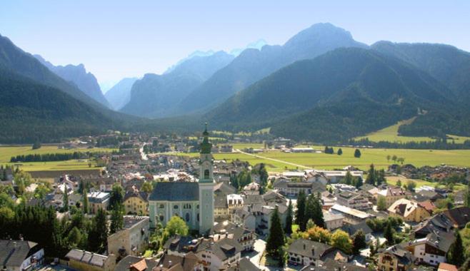 Une petite ville avec des montagnes en arrière-plan dans l'établissement Aurturist Dobbiaco Roulette, à Dobbiaco