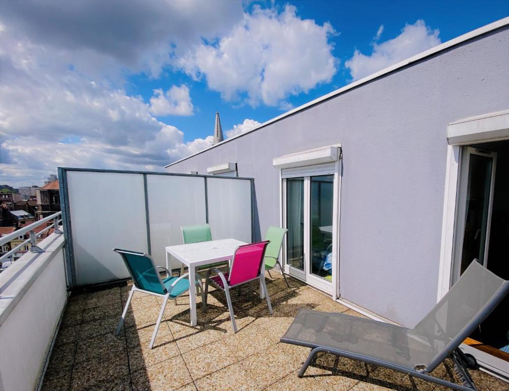 eine Terrasse mit einem Tisch und Stühlen auf dem Balkon in der Unterkunft StudioLille - Gambetta in Lille