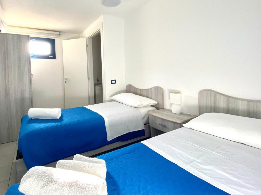 Pokój hotelowy z 2 łóżkami i lustrem w obiekcie Galatea House w mieście Marinella di Selinunte