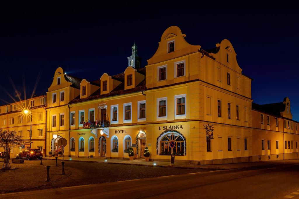 a large yellow building is lit up at night at Hotel U Sládka in Chodová Planá