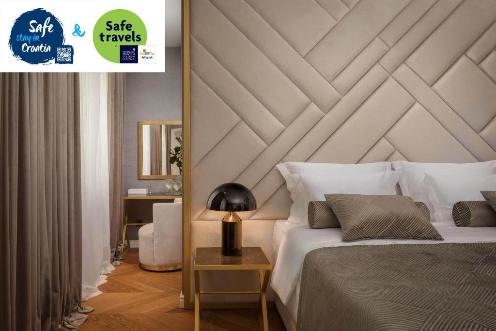 a bedroom with a white bed with a wooden headboard at Five Elements Luxury Rooms in Split