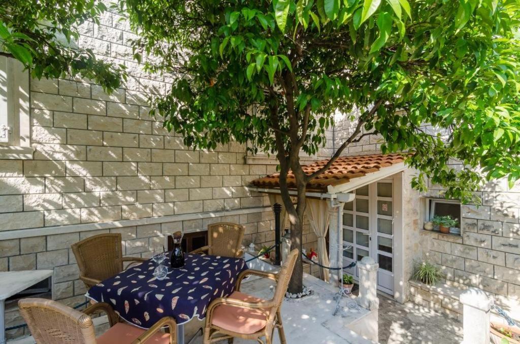 uma mesa e cadeiras com uma mesa e uma árvore em Apartment Wild Orange em Dubrovnik