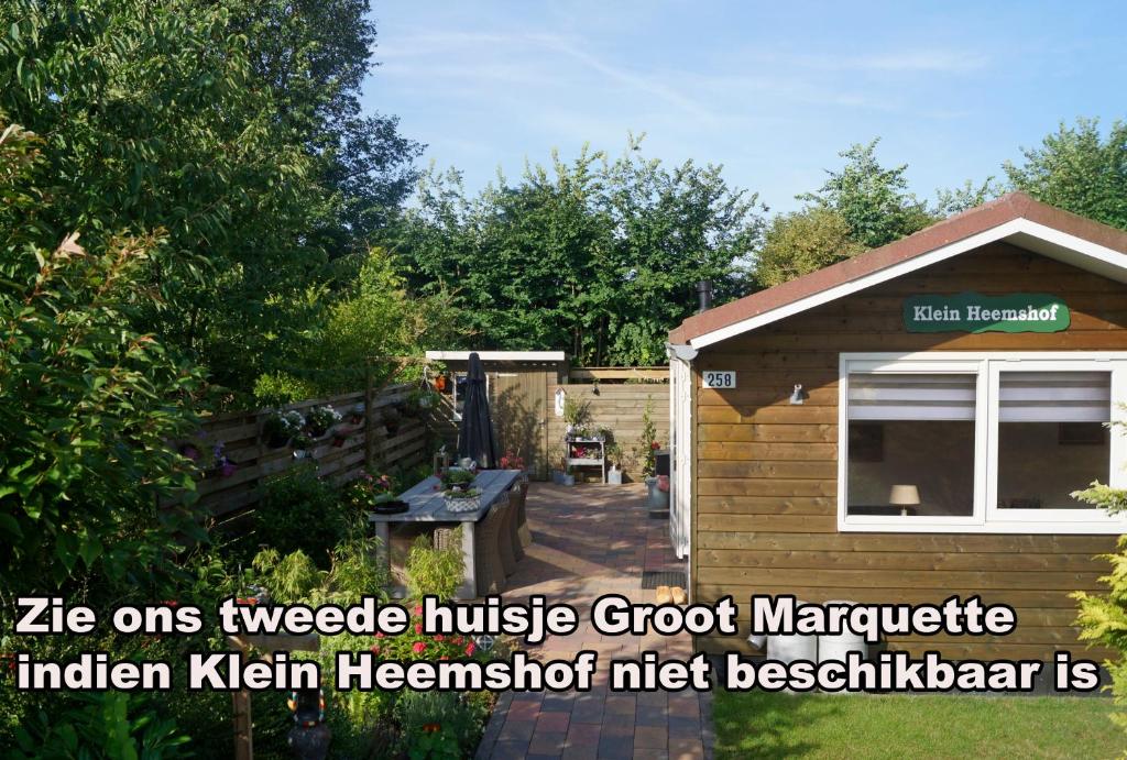una pequeña casa de madera con patio trasero en Klein Heemshof - Noord Holland aan uw voeten, en Warmenhuizen