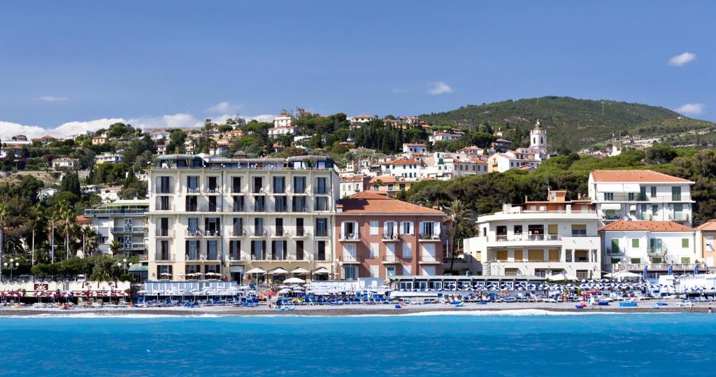 a group of buildings on a beach next to the water at Hotel Parigi & Spa in Bordighera