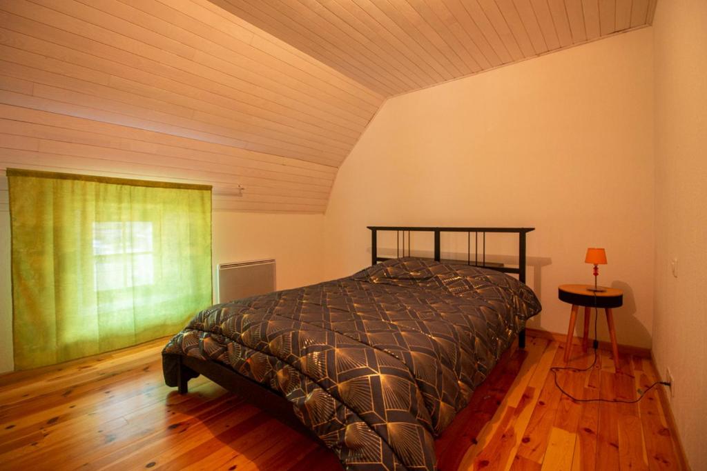 a bedroom with a bed and a wooden floor at Village de Nasbinals Aubrac Electro Vélo in Nasbinals