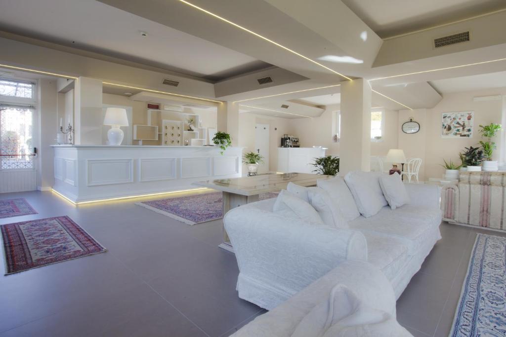 a living room with a white couch and a kitchen at Relais Le Felci in Fiuggi