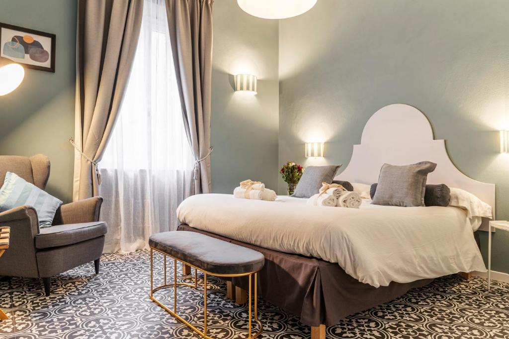 sypialnia z dużym białym łóżkiem i krzesłem w obiekcie La Lu cozy rooms 2 w Pizie