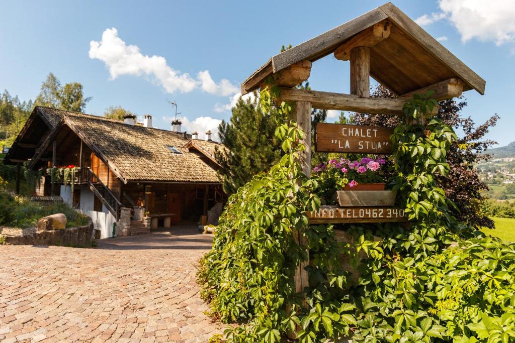 a sign in front of a building with flowers at Chalet La Stua in Cavalese