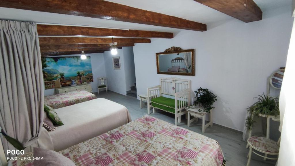 a bedroom with two beds and a table and chairs at Cueva de la abuela in Los Carriones