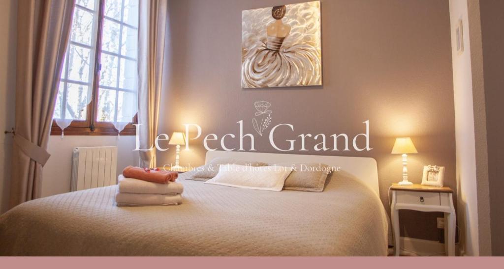 a bedroom with a bed with a sign that says real grand at Chambres & Tables d'hôtes Le Pech Grand in Saint-Sozy