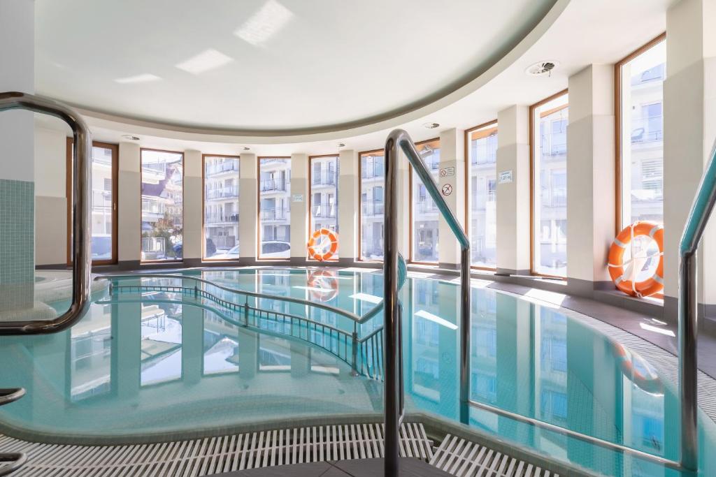 a swimming pool in a building with windows at Stara Polana Apartamenty & Spa Zakopane by Noclegi Renters in Zakopane