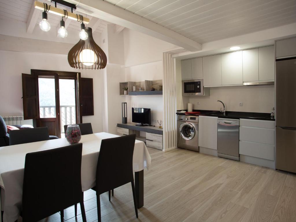 a kitchen and living room with a table and chairs at Apartamento Subida Las Torres in Albarracín