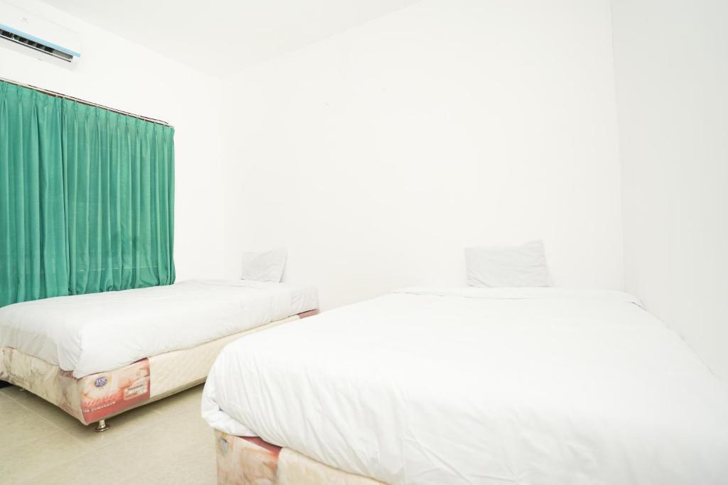 Postel nebo postele na pokoji v ubytování Merapi Inn Syariah by ecommerceloka