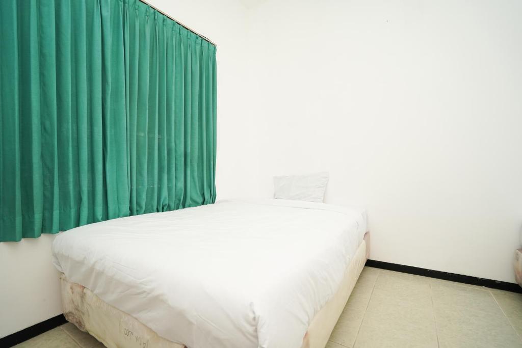 Postel nebo postele na pokoji v ubytování Merapi Inn Syariah by ecommerceloka