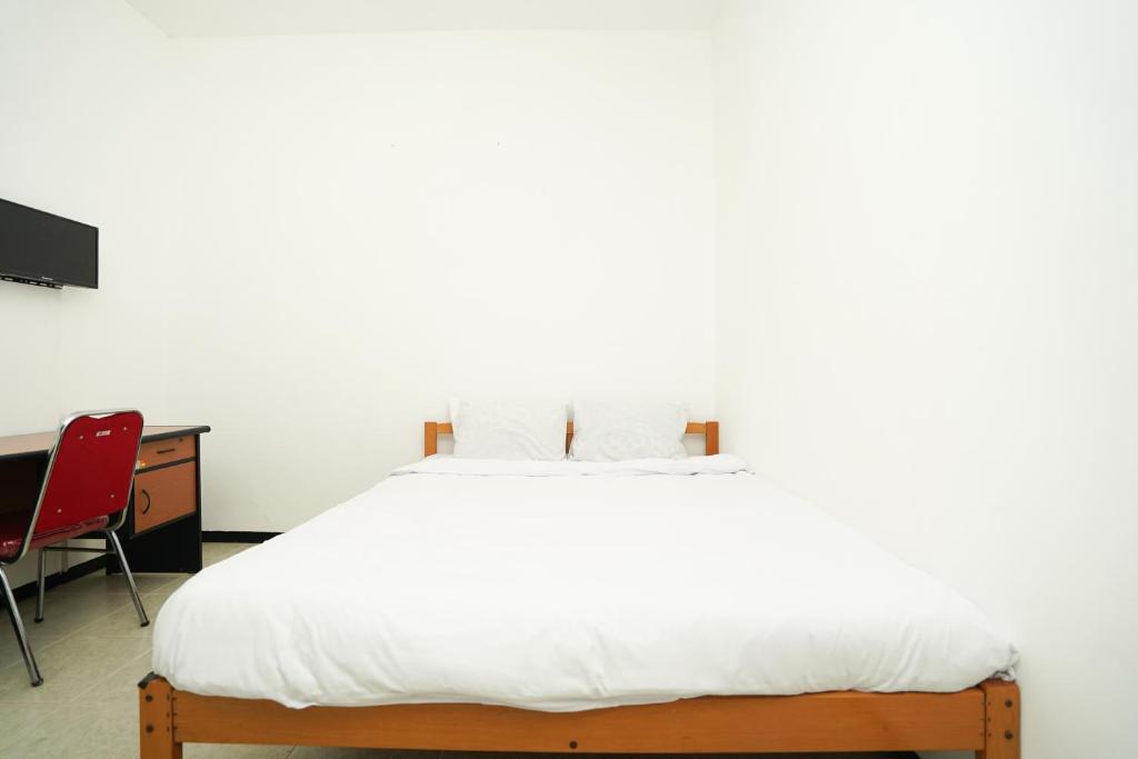 Postel nebo postele na pokoji v ubytování Merapi Inn Syariah by ecommerceloka