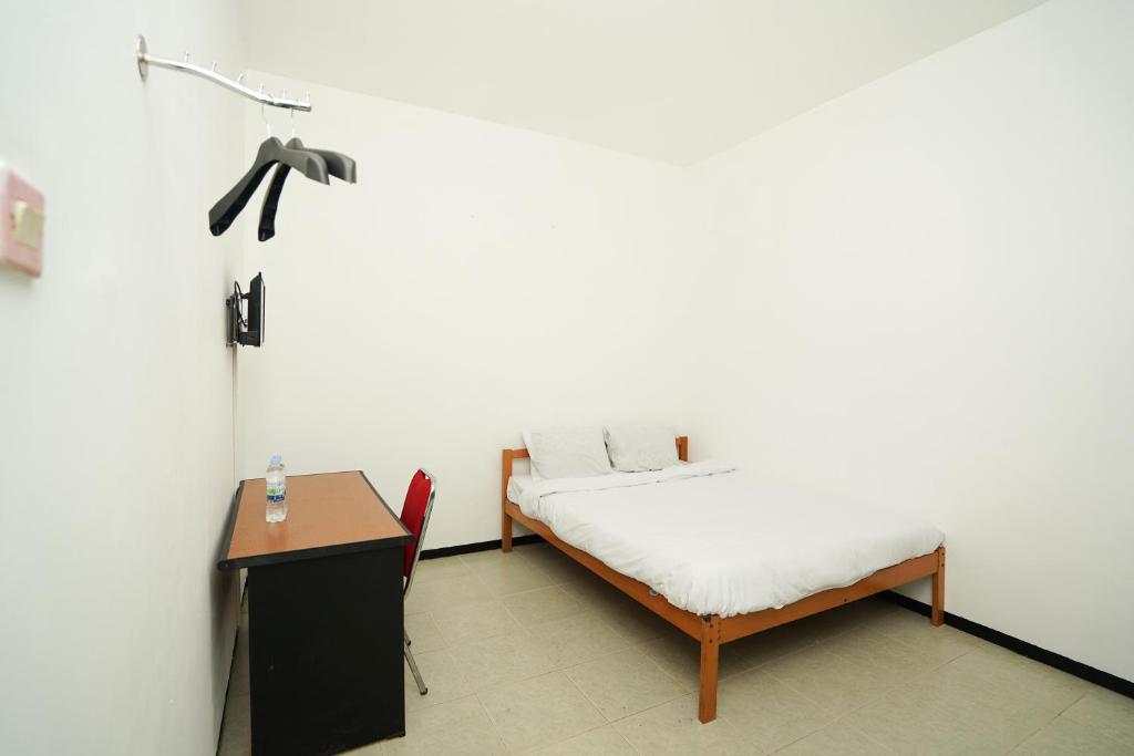 Postel nebo postele na pokoji v ubytování Merapi Inn Syariah by ecommerceloka