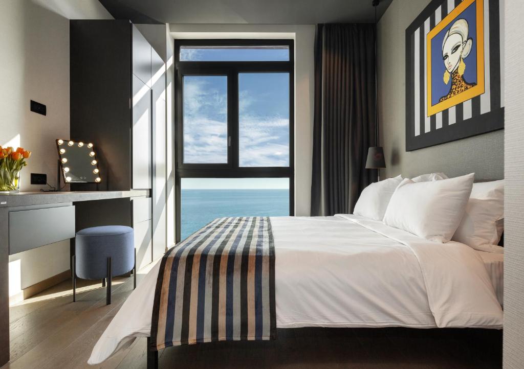 a bedroom with a large bed and a large window at ONLY Boutique Suites & Residences in Limassol