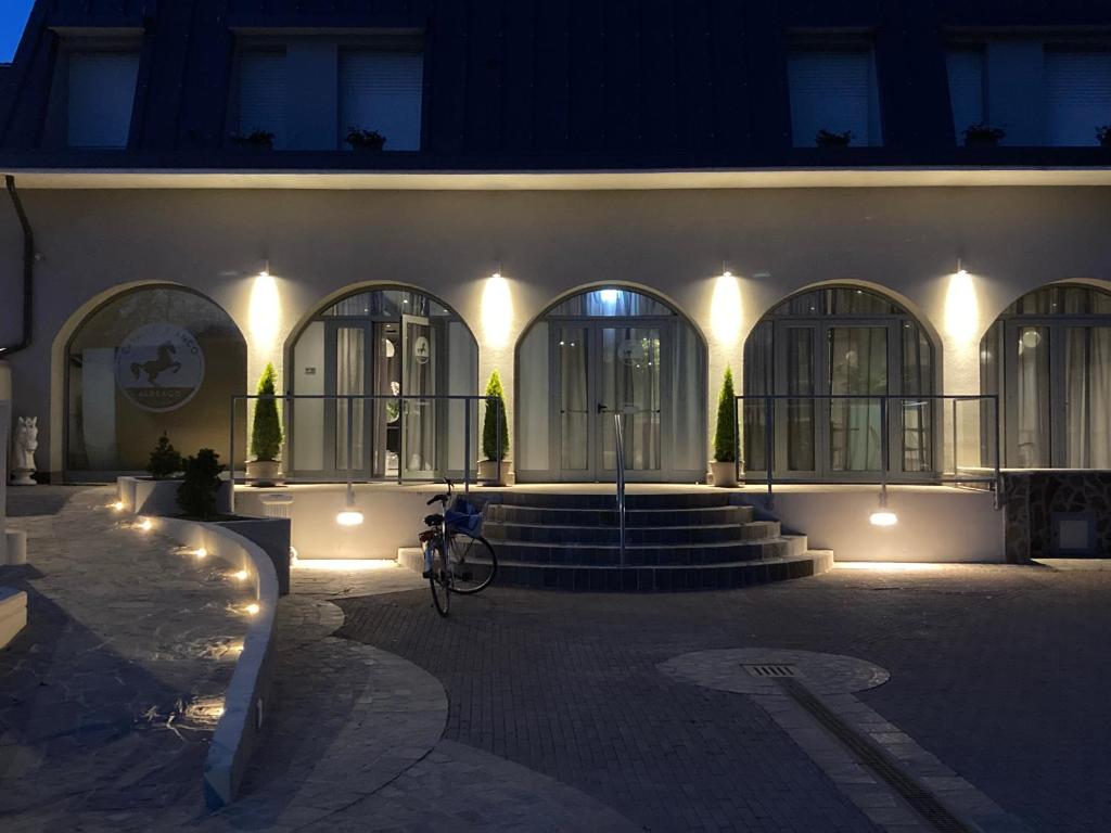 a building with a bike parked in front of it at night at Hotel Cavallo Bianco in Reggiolo