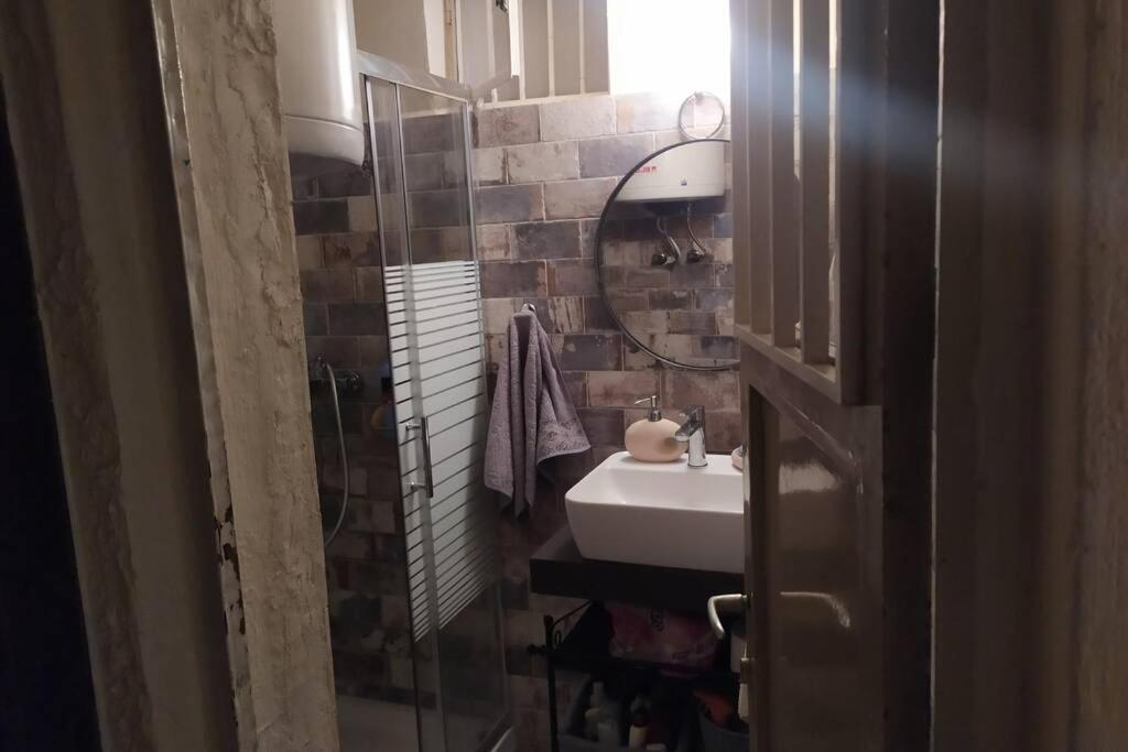 uma casa de banho com um lavatório e um espelho em Maro's Guesthouse em Agios Lavrentios