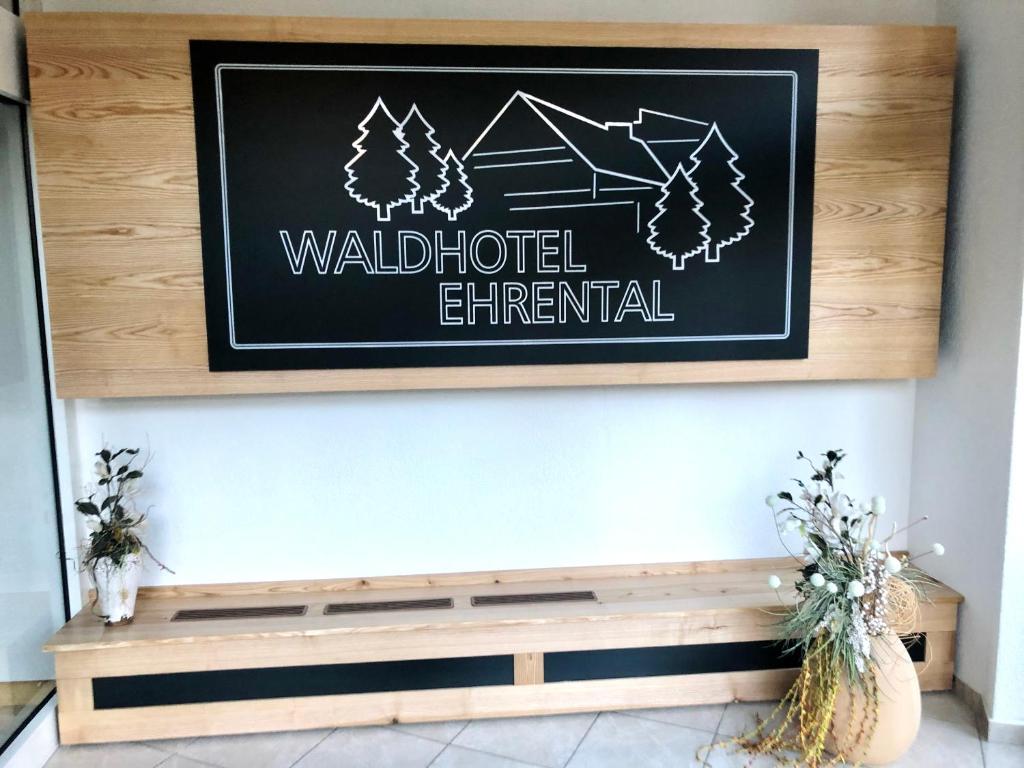 a sign on a wall above a wooden bench at Waldhotel Ehrental in Schmalkalden