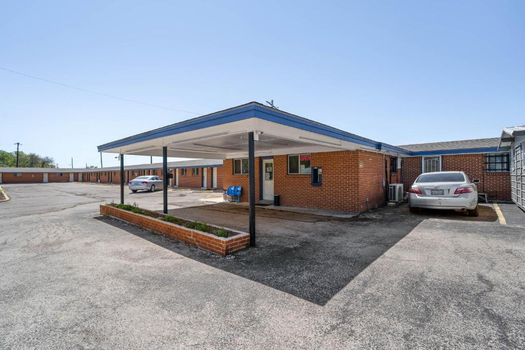 a gas station with a canopy in a parking lot at OYO Hotel Luling TX Downtown I-10/US-90 in Luling