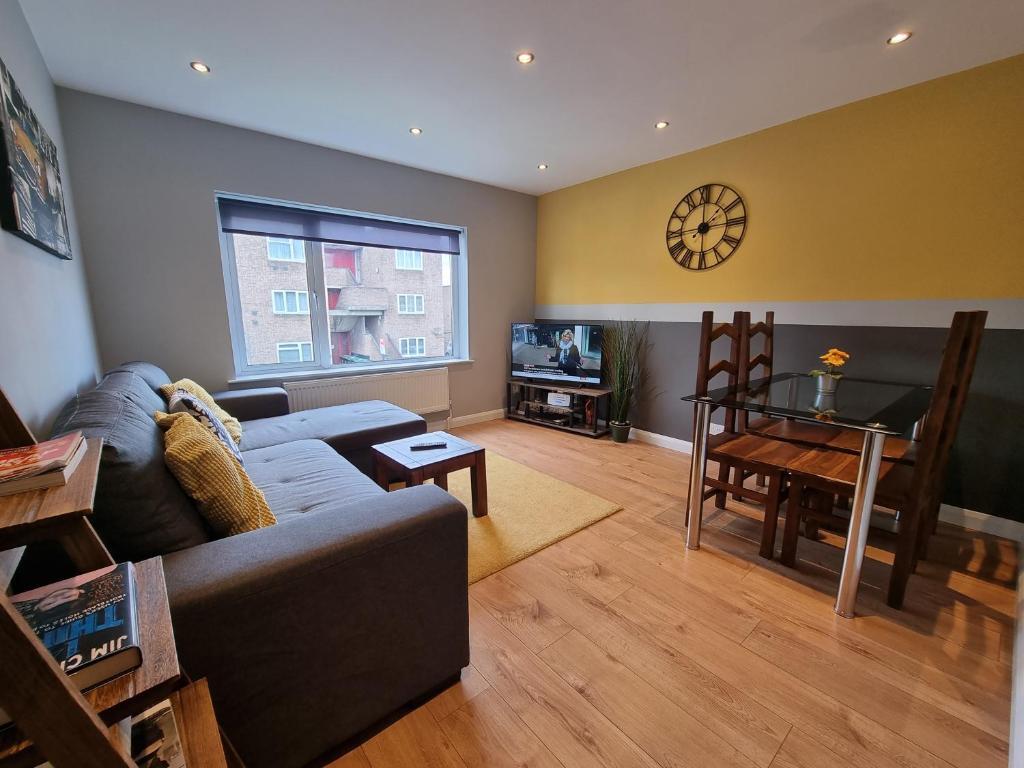 a living room with a couch and a table at 144 - ExcellentStays - 2 Bedroom Flat in Stanwell