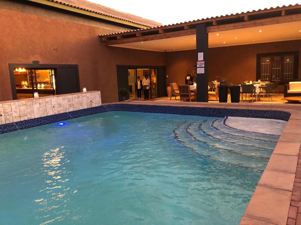 a swimming pool in the middle of a hotel at Prospectors Inn in Lüderitz