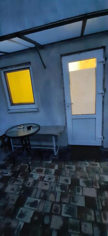 a room with a table and two windows at Дом с удобствами in Cherkasy
