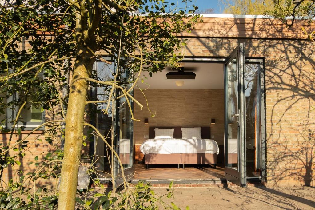 ein Schlafzimmer mit einem Bett auf einer Terrasse in der Unterkunft Kwadijkerbos in Kwadijk