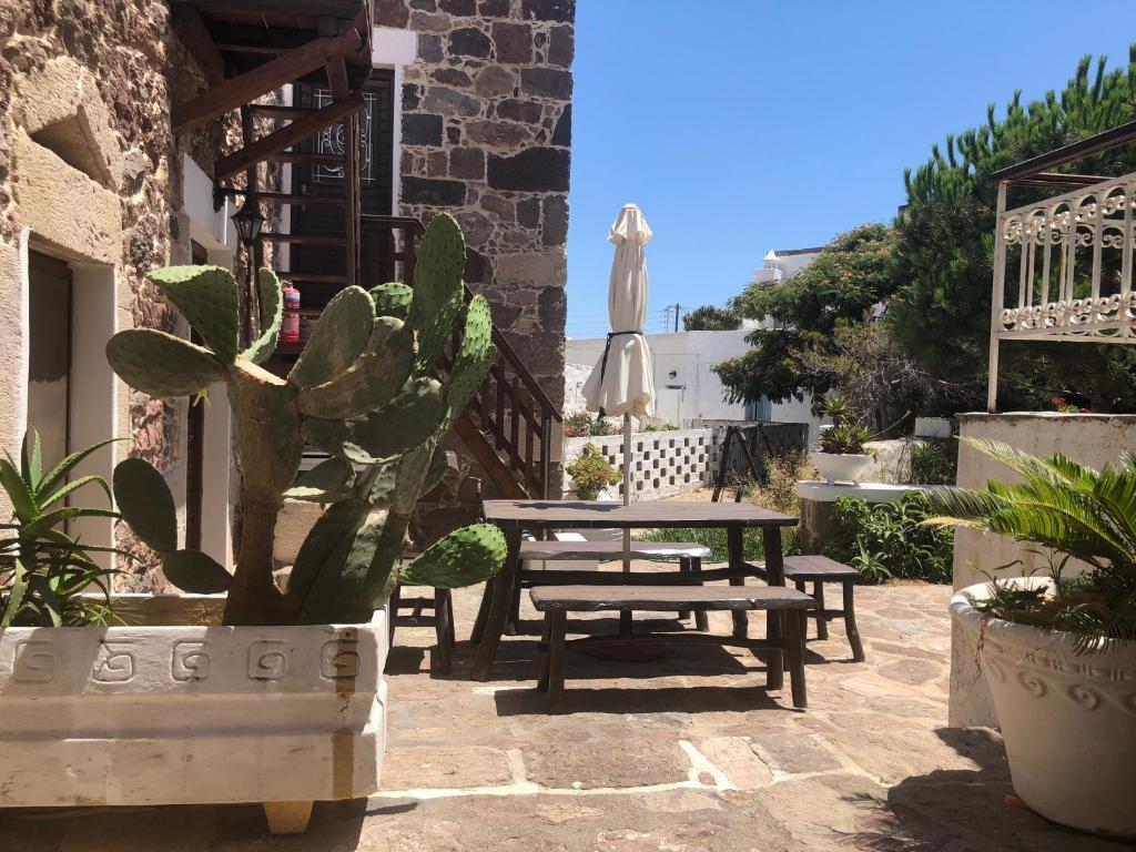 a patio with a table and chairs and a cactus at Machi's House in Plaka Milou