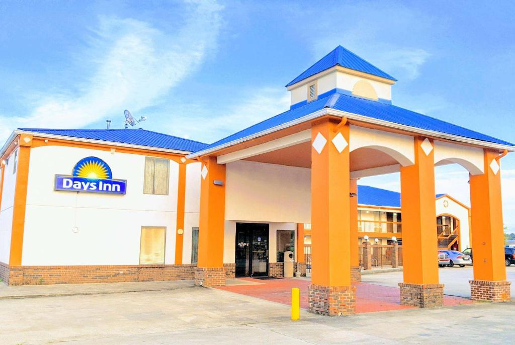 a building with orange columns and a blue roof at Days Inn by Wyndham Decatur Priceville I-65 Exit 334 in Decatur