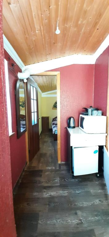 a room with a kitchen with red walls and a hallway at Дом от владельца с парковой in Cherkasy