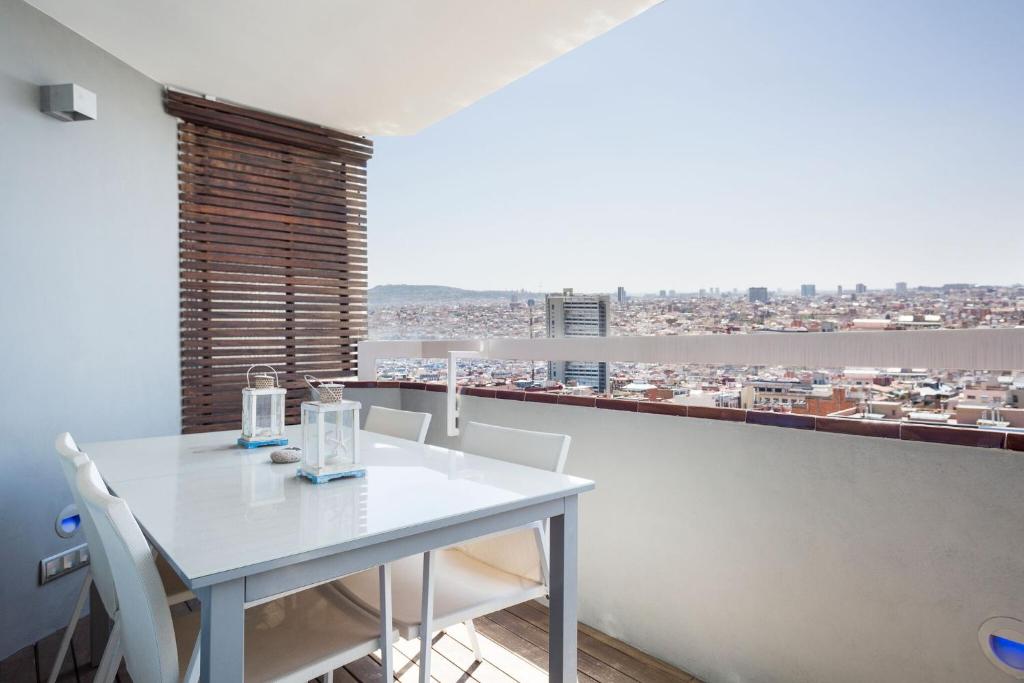 una mesa blanca y sillas en una habitación con vistas en Stay U-nique Apartments Sardenya, en Barcelona